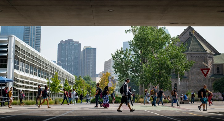 Students walking on campus next to the library