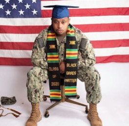 Student in military garb and graduation cap with a scarf that says 