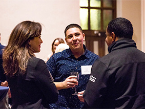 Three people talking in at a networking event