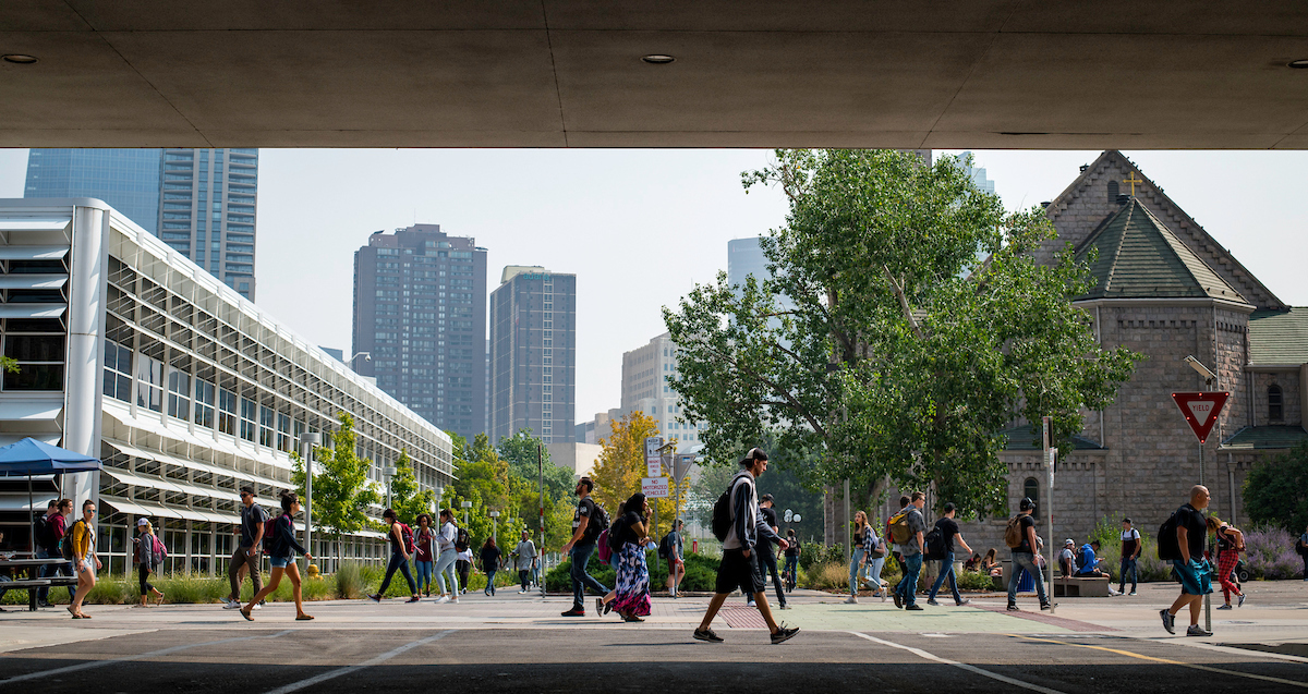 Students walking on campus in front of the Auraria library