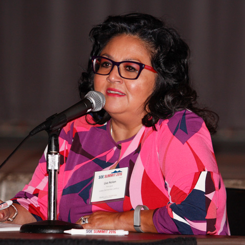 Decorative: Image of Lisa Nolan sitting and speaking at a microphone,