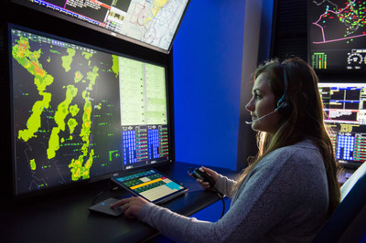 A woman utilizes advanced air traffic control technology.