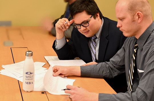 Two MBA students analyzing a table.