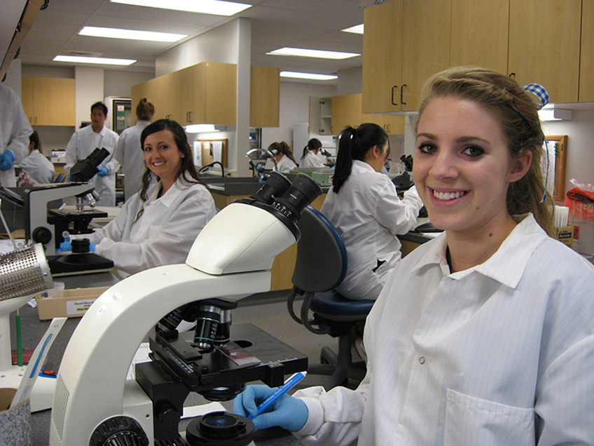 Students looking at microbiology slides under the microscope.