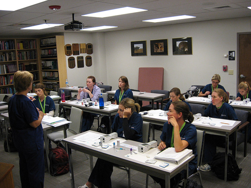 Students listening to a point of care lecture in class.room