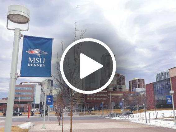 Photo of an MSU Denver banner with campus behind it and the play button in the foreground