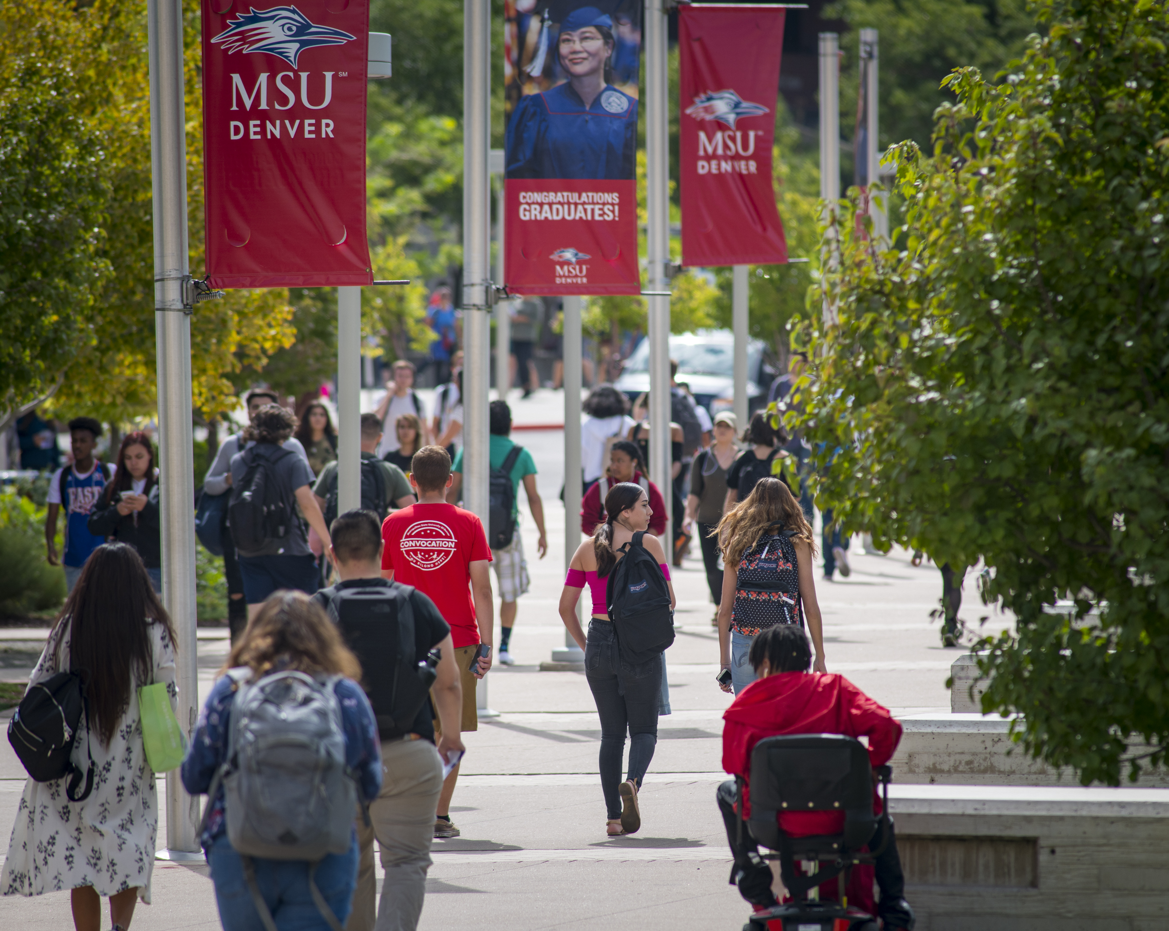 Students on campus near poles advertising MSU Denver banners