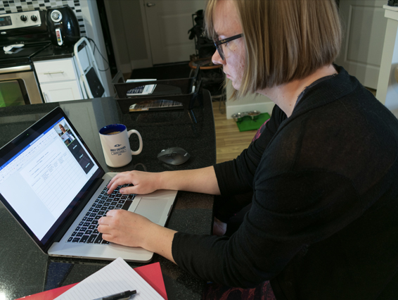 Student working at their computer in their kitchen