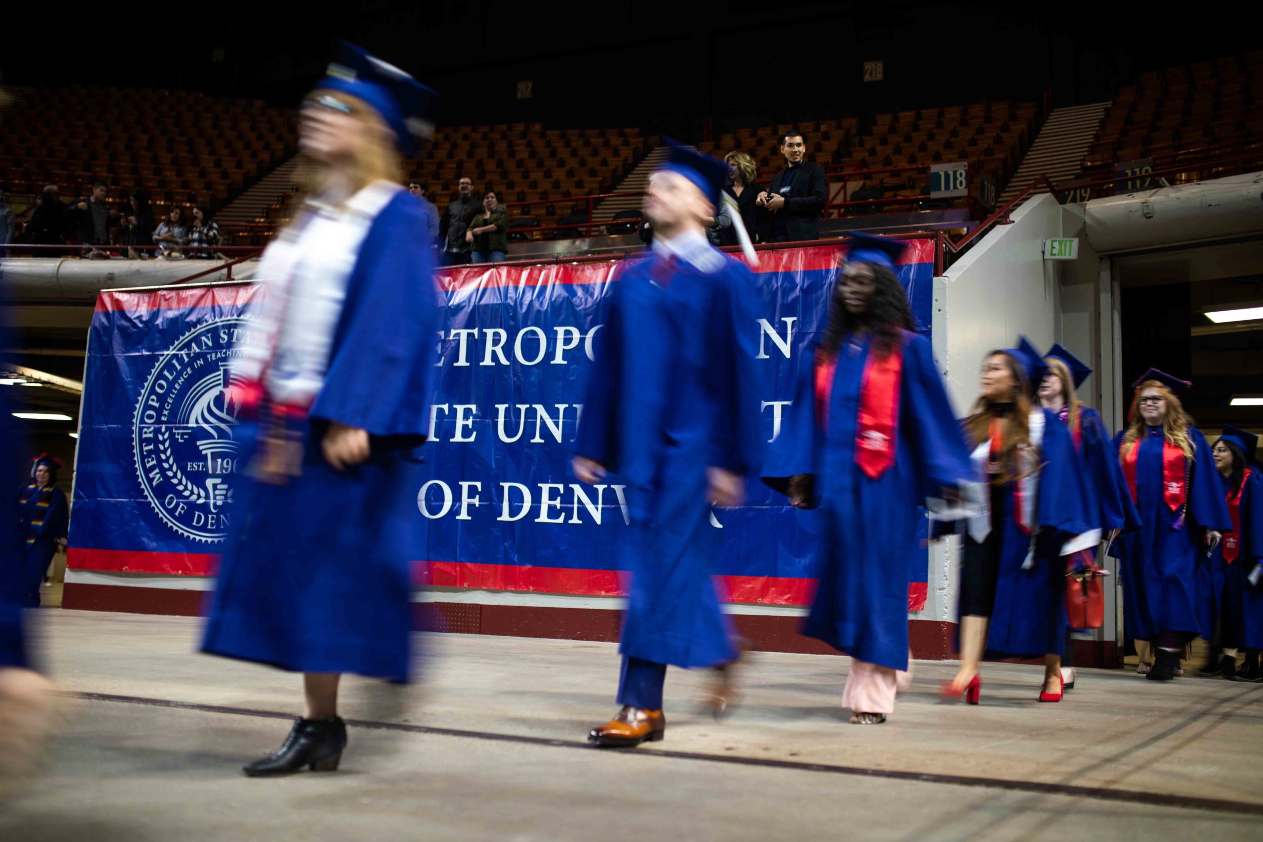 Graduates walking quickly into the Denver Coliseum.