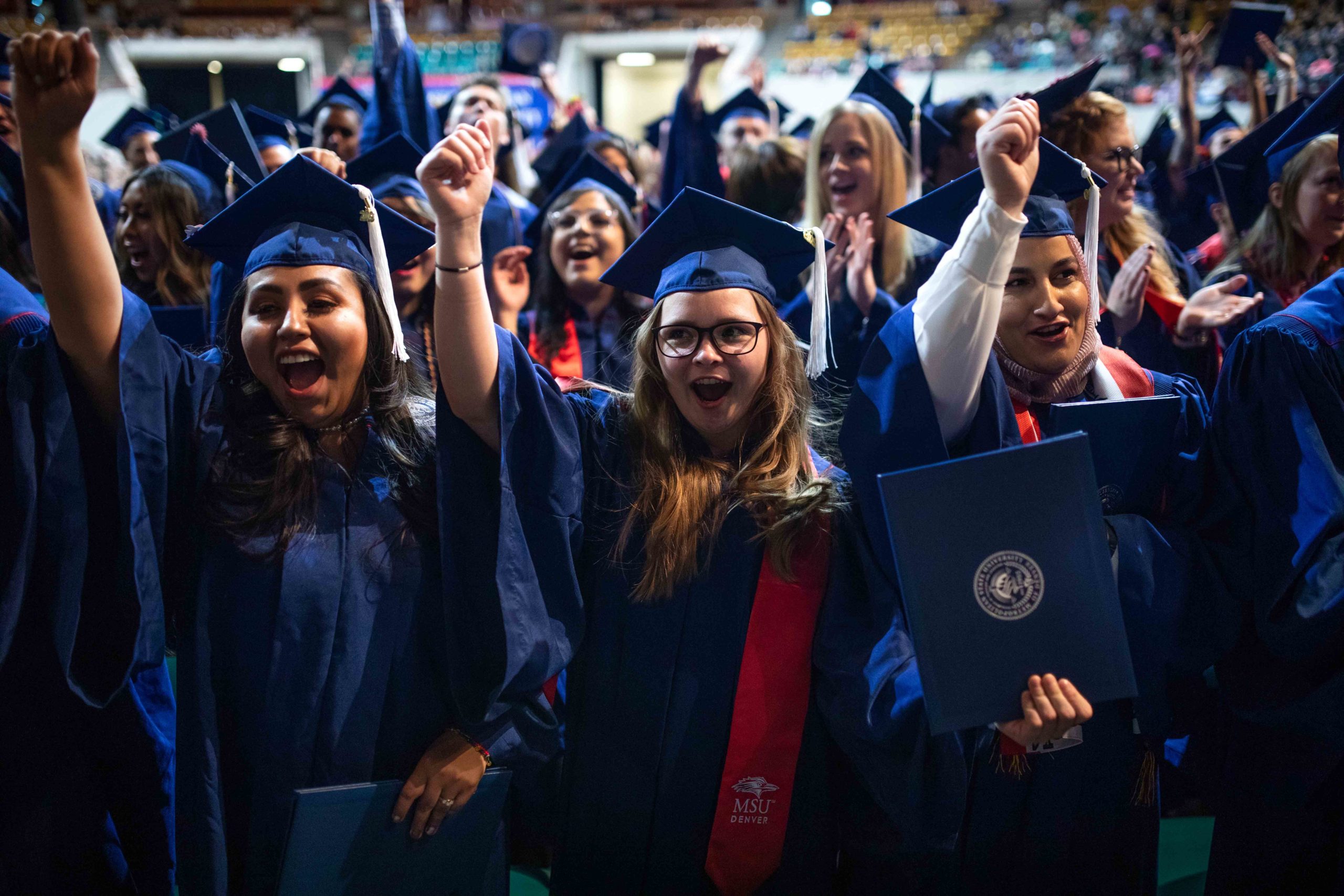 Graduates cheering during the commencement ceremony.