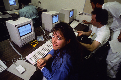 Student smiling in front of 1990s computer