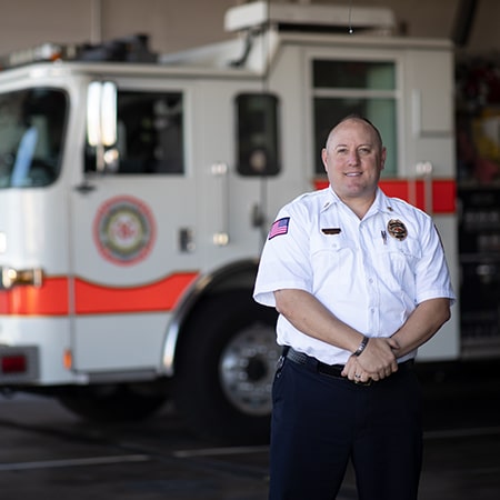 Fire Chief Kevin Vincel poses in front of a fire engine.