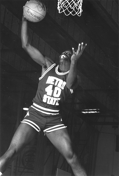 Men's basketball athlete dunking a basketball