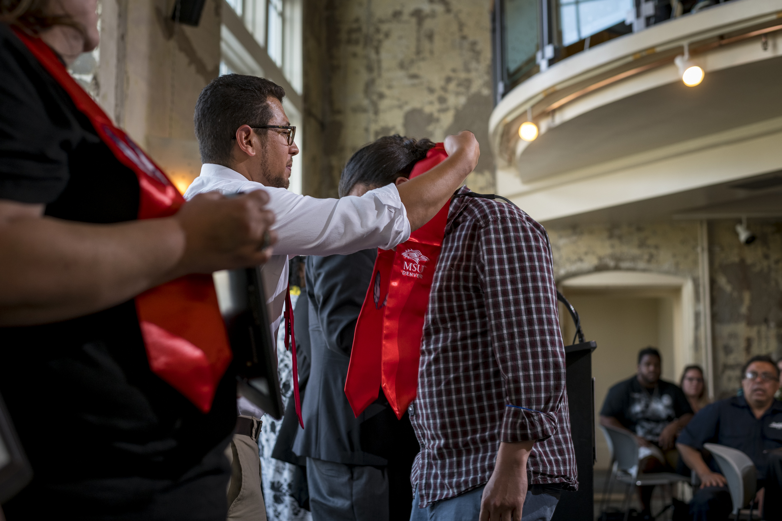 A man bestowing a stole onto a graduate