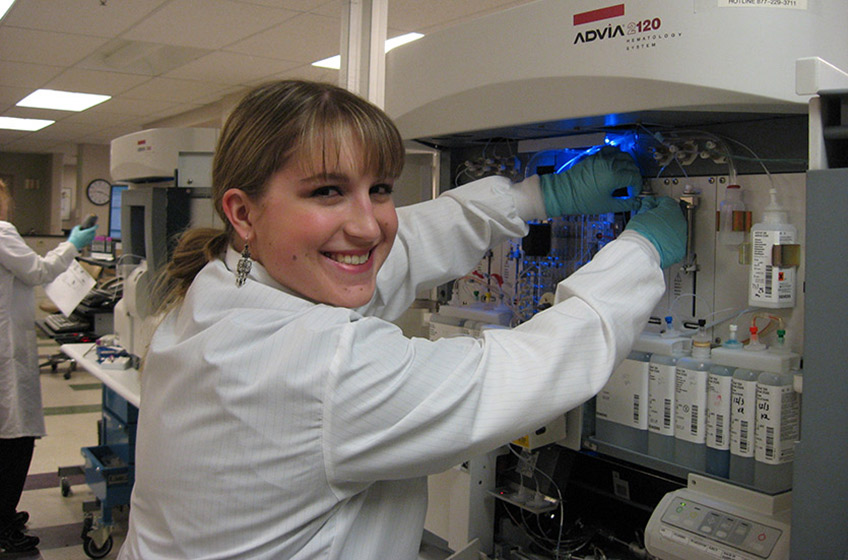 Student operating an instrument in urinalysis