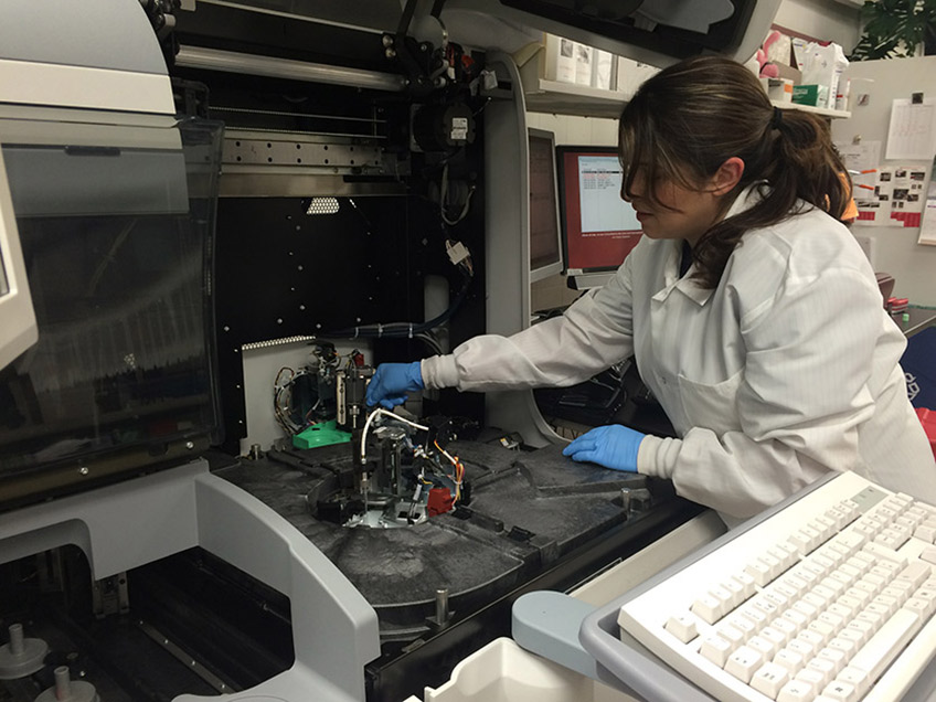 Student performing maintenance on an instrument in the chemisty lab