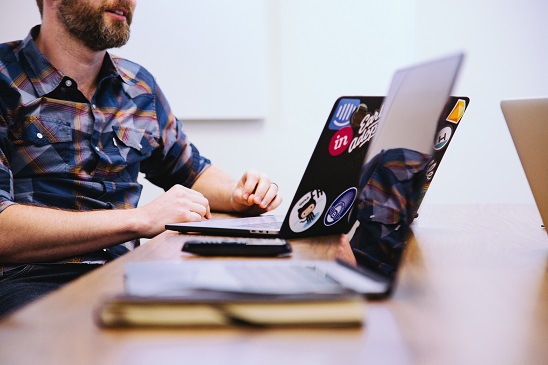 A young man sitting at a desk using a laptop