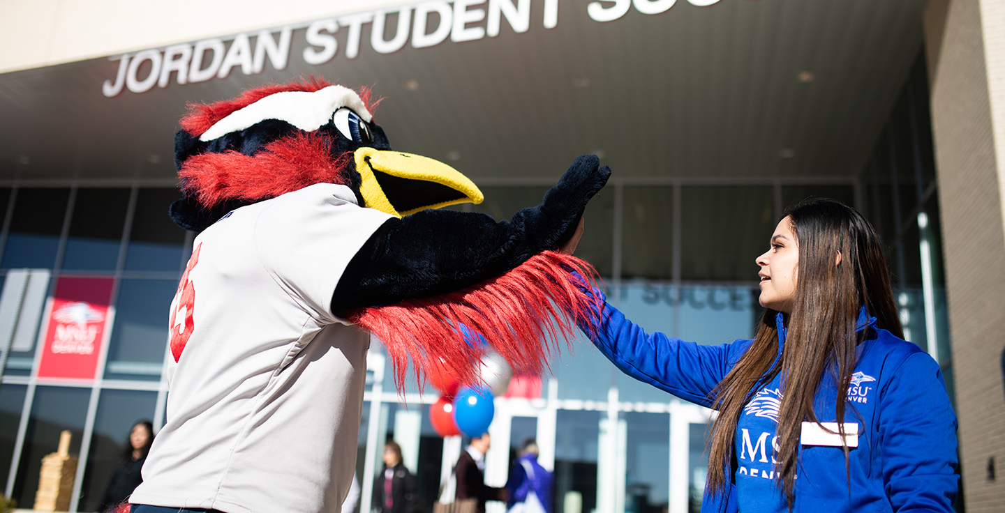 Rowdy high fives a Crew in Blue team member