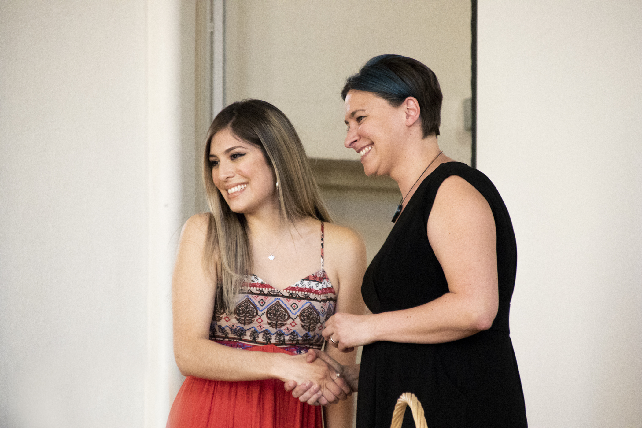 Two women shaking hands at the BSW Pinning ceremony