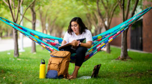 A student studies on a hammock on Auraria Campus.