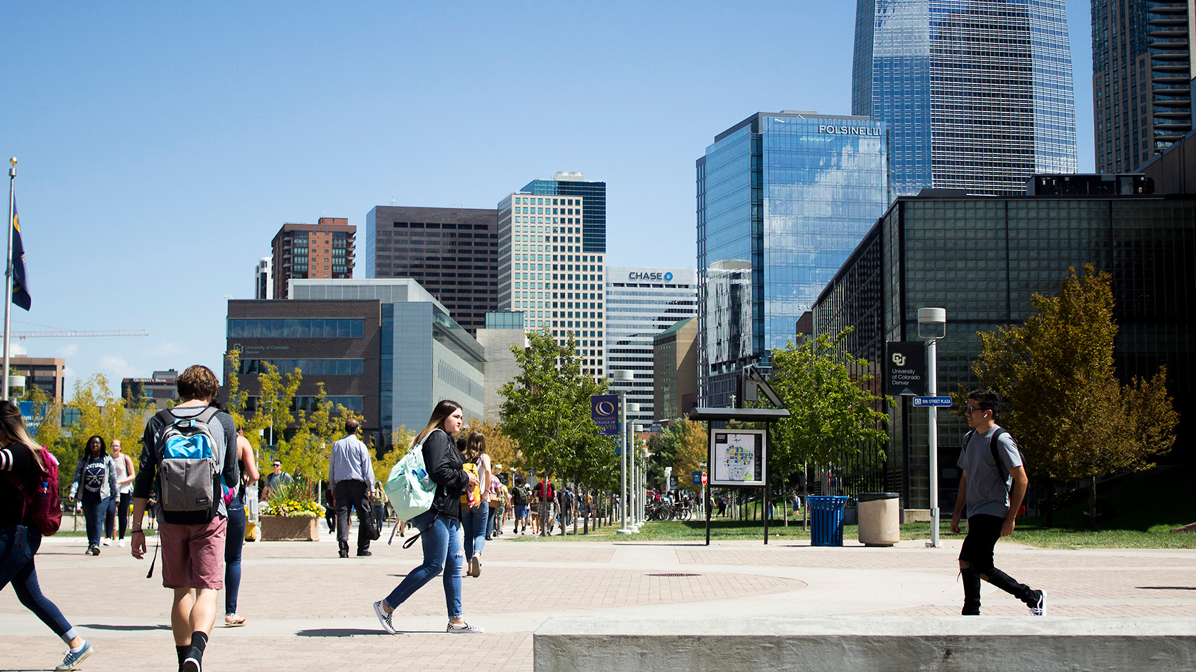 Students walking on campus with denver skyline