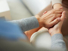 A person holding another person's hand in a compassionate way