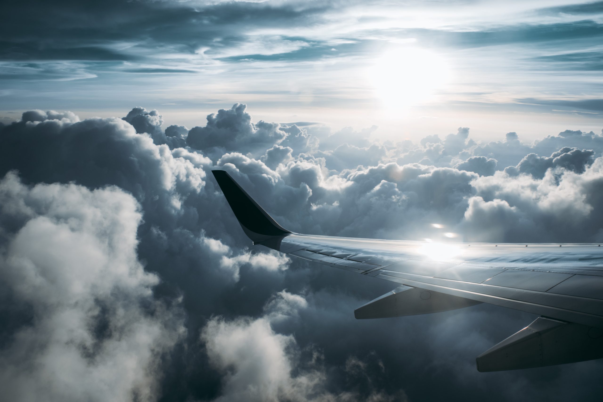 Passenger view of an airplane wing and the sky at sunset.