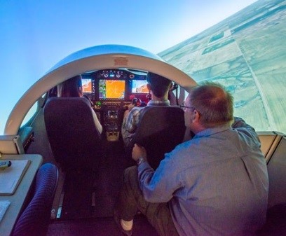 A faculty member giving instruction to 2 students in the jet simulation laboratory.