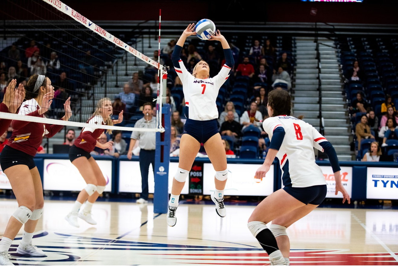 Women's volleyball team setting the ball