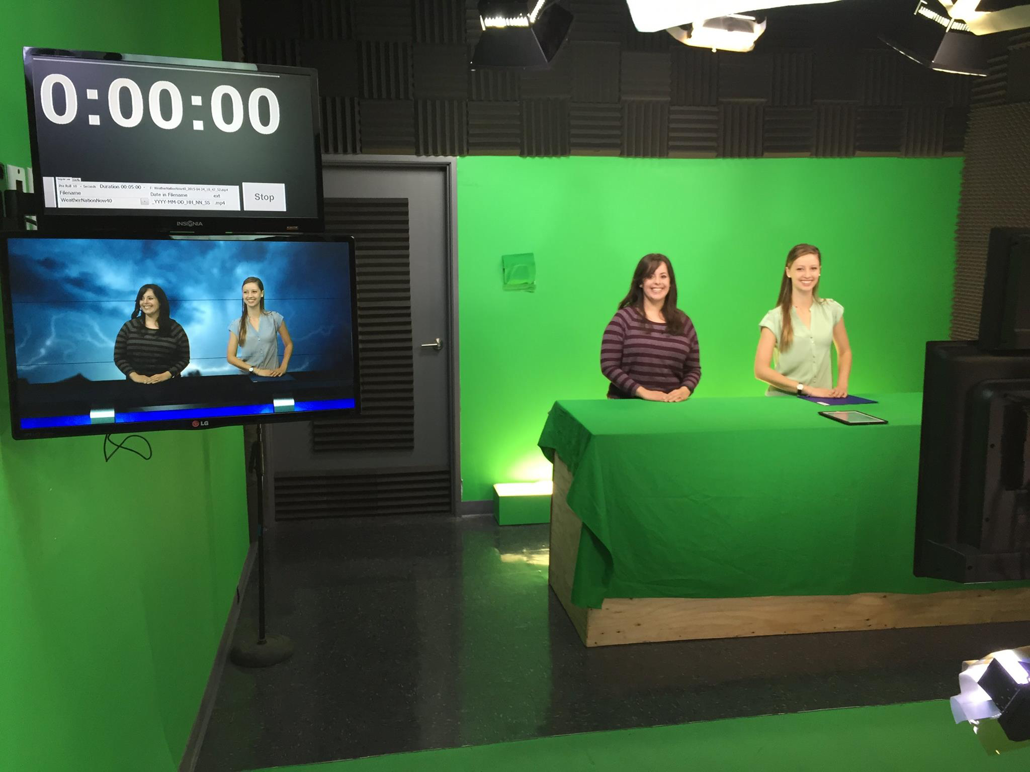 Two students in front of a green screen at a TV station
