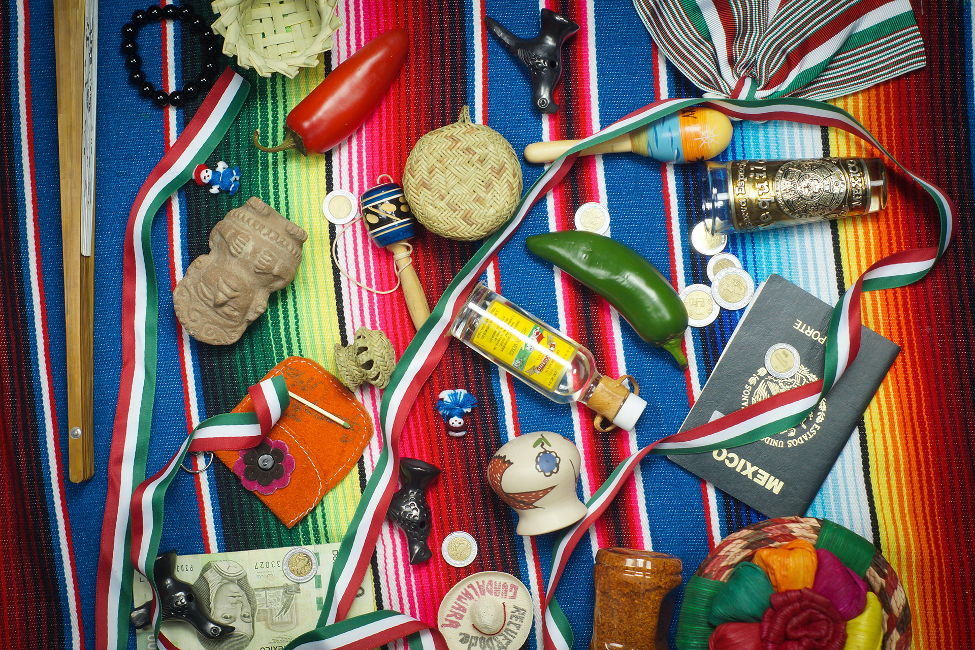 Mexican blanket with peppers, passport, maracas and various items lying on top