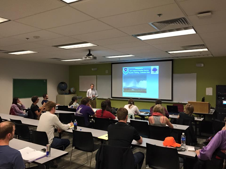 Students in a classroom watching the NWS lead train them on storm spotting