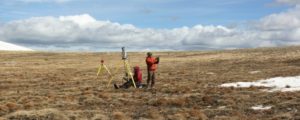 Two people in a field performing lidar survey measurements