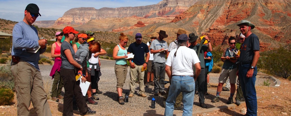 Geology Students listening to an instructor lecture with a mesa in the background