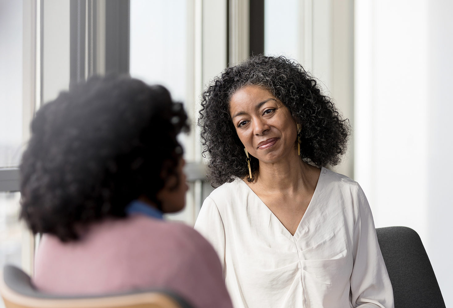 Woman working in healthcare looks an recognizable patient