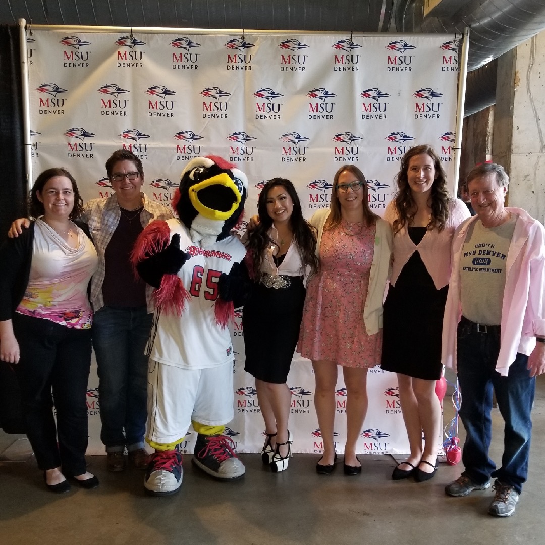 Math and Stats faculty posing with Rowdy in front of an MSU Denver themed backdrop