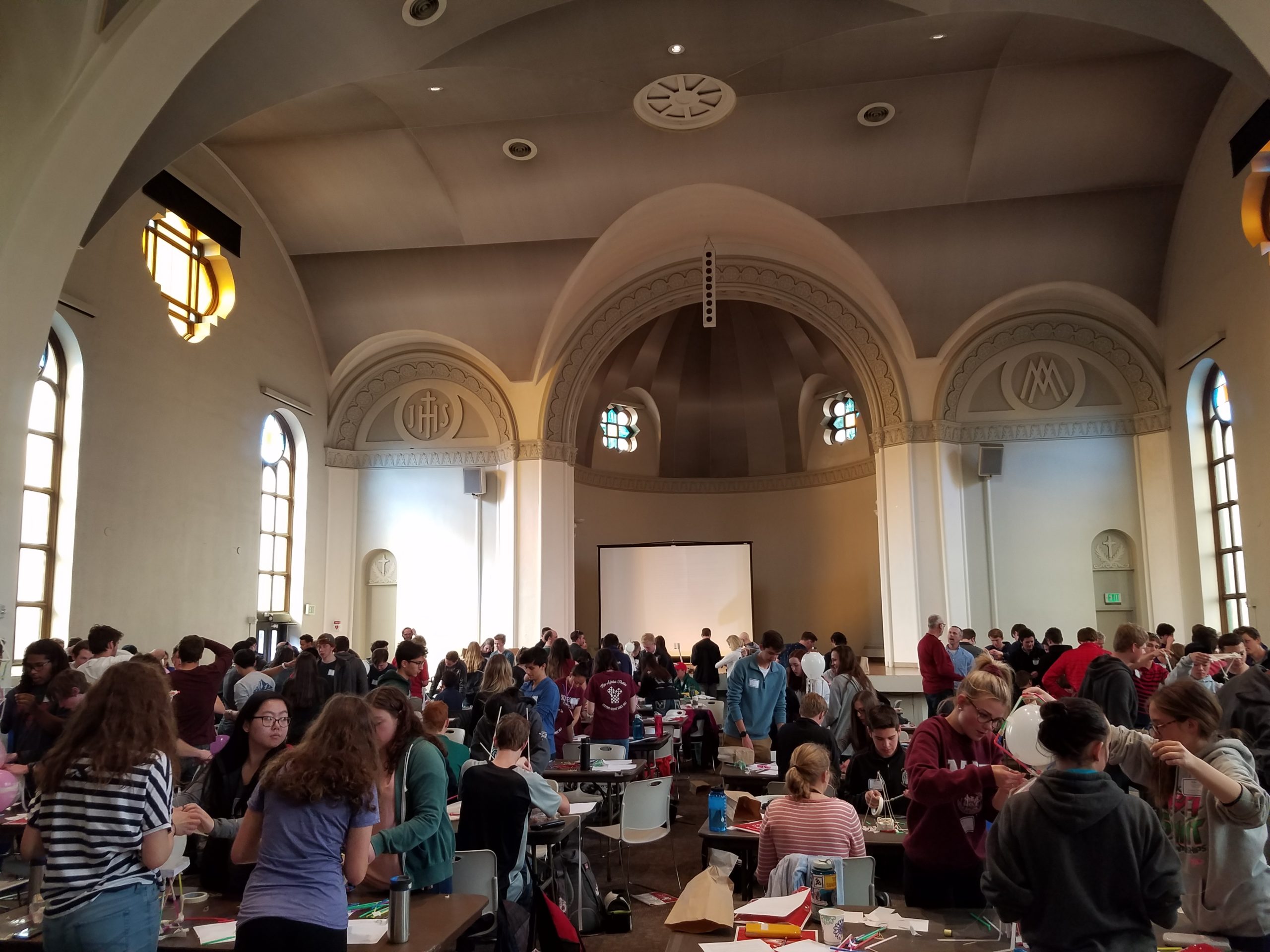 Students gather around tables at the Math day celebration in St. Cajetan's church