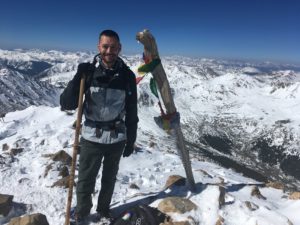 Barry Miller standing on a snow covered mountain peak