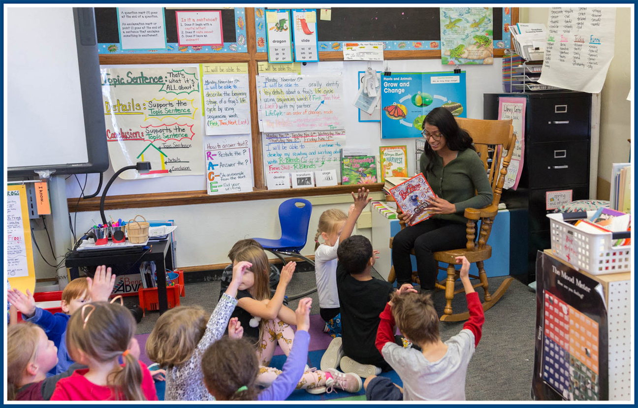 Student teacher reading to a room of elementary school students.