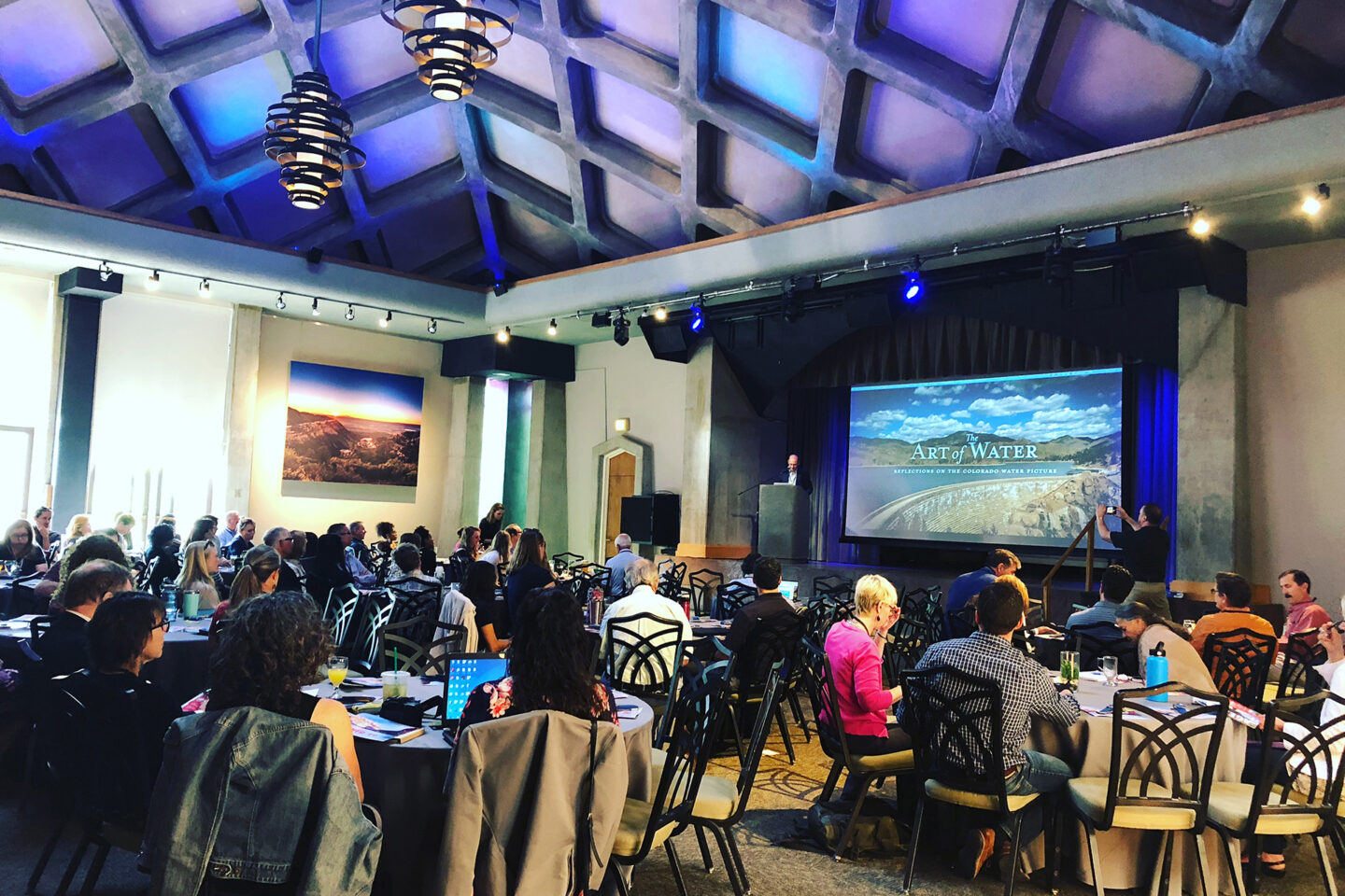 Wide shot of a conference with someone presenting