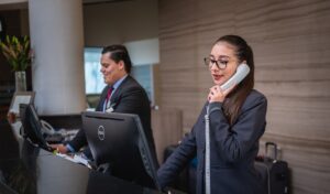 Two receptionists at their computers on the phone