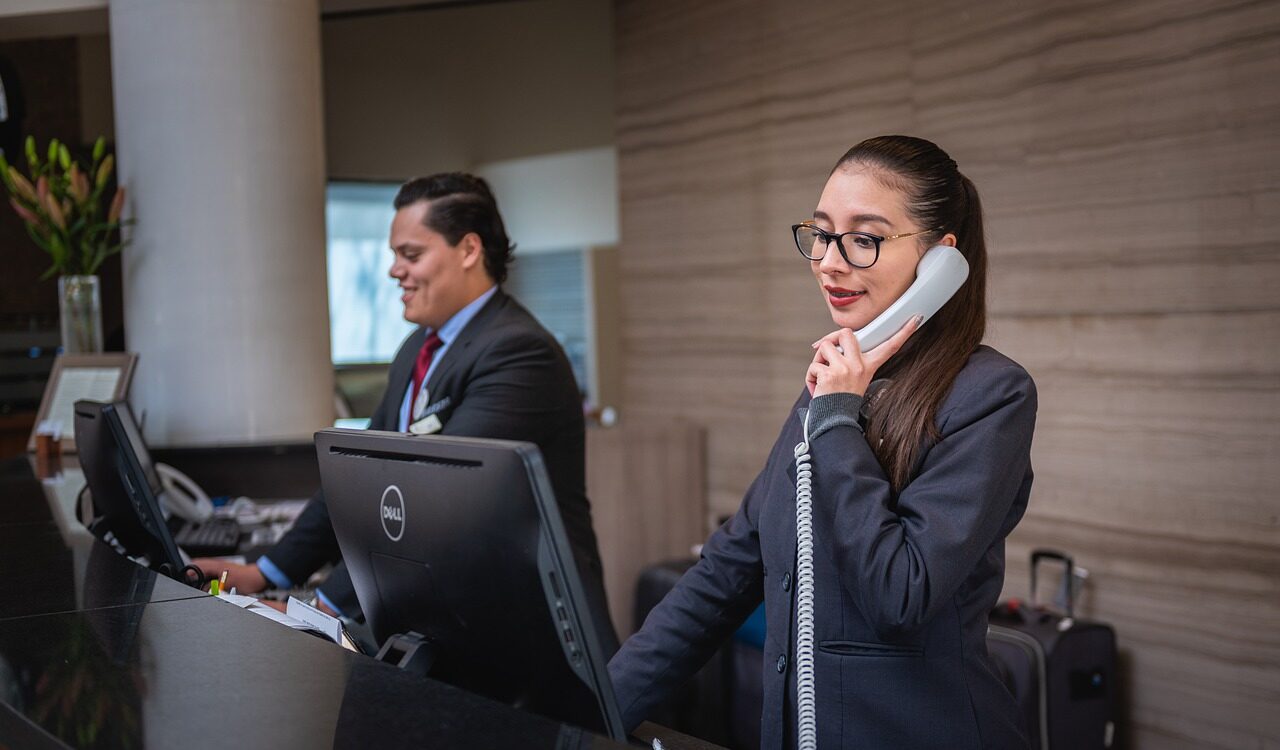 Two receptionists at their computers on the phone