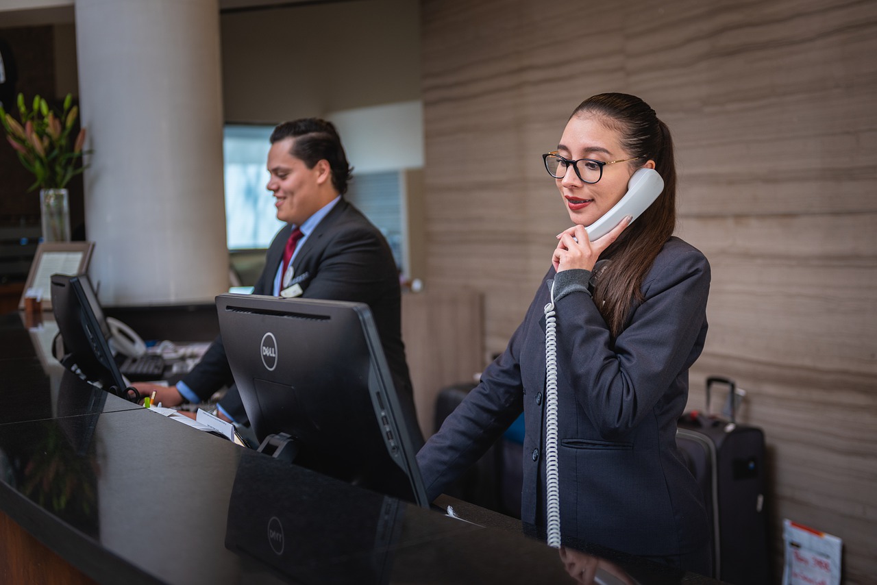 Two receptionists at their computers on the phone