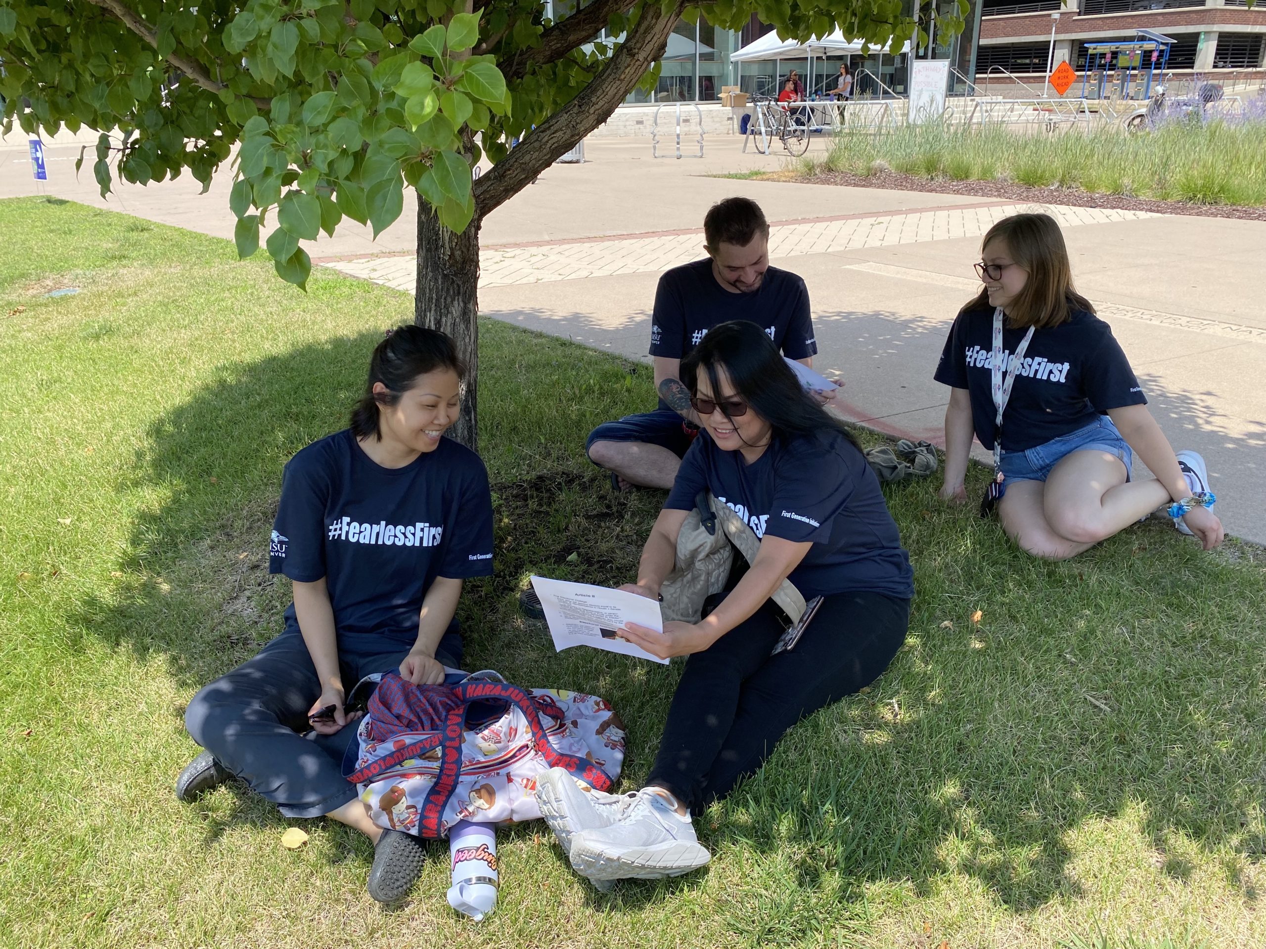 students talking under a tree on campus