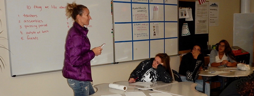 Photograph of a teacher instructing children in a classroom.