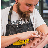 Student sculpting a spiky arm guard