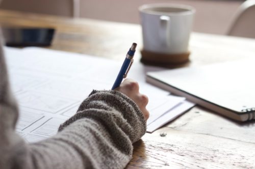 Woman writing on paper with a pen