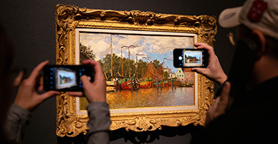 People taking photographs of a Monet painting