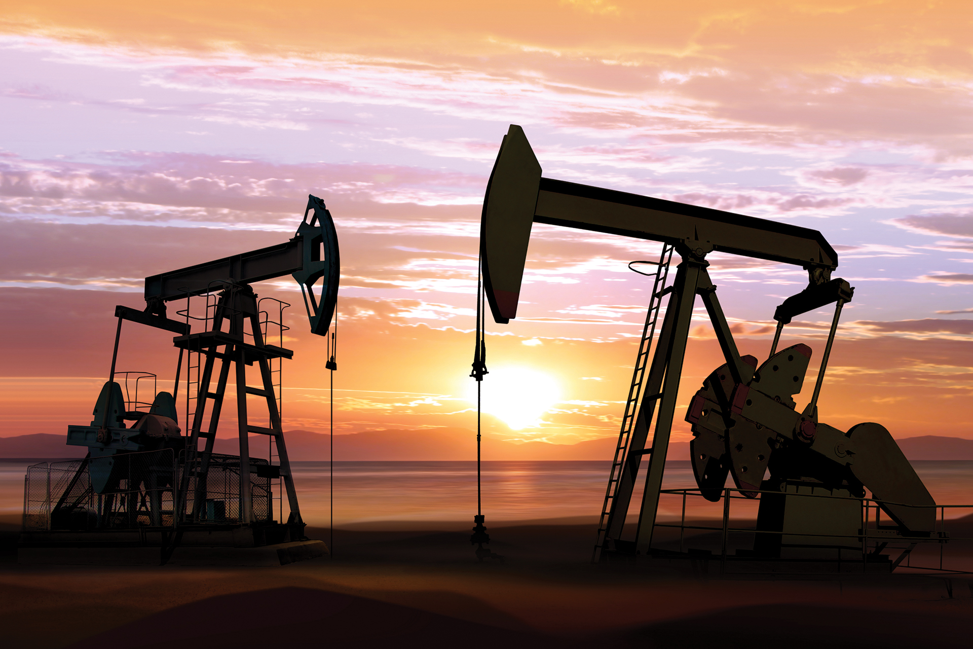 silhouette of working oil pumps on sunset background