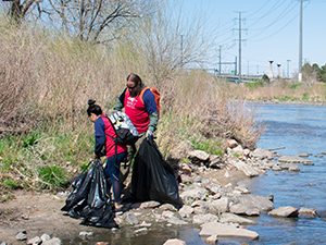 Volunteers picking up trash along the South Platte River.